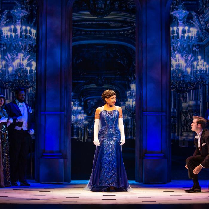 Anastasia dressed in a blue ballgown mid stage