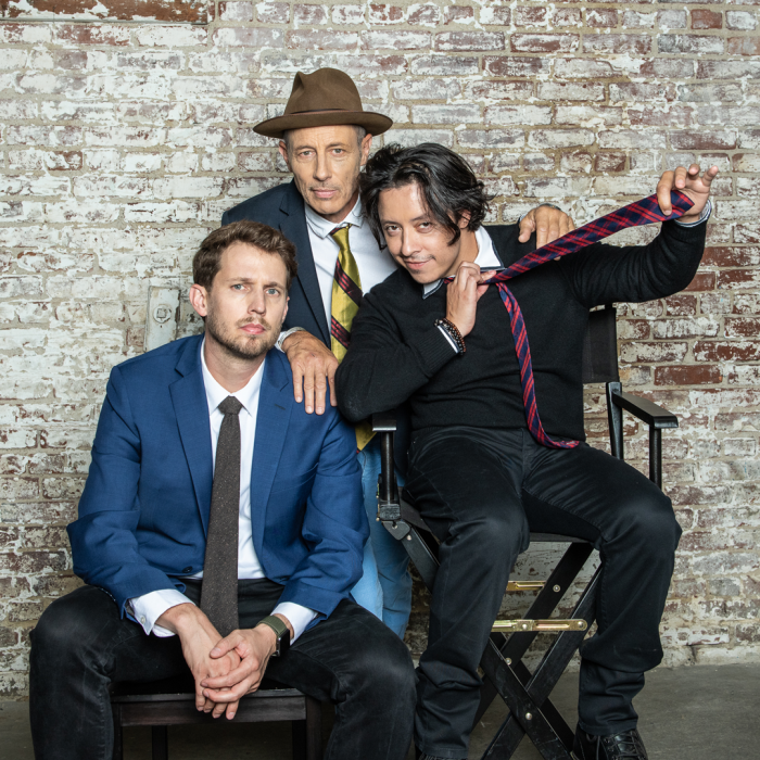 Three guys from Napoleon Dynamite posing in front of a brick wall