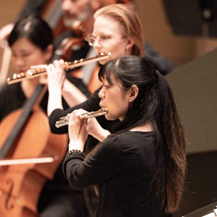 Close up of an orchestra focusing on a picalo player