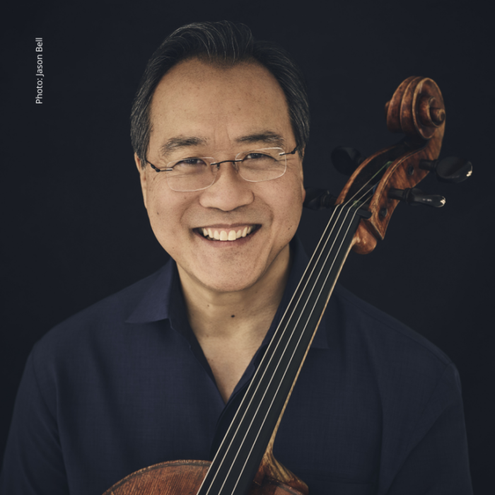 Yo Yo Ma smiling at the camera holding his cello