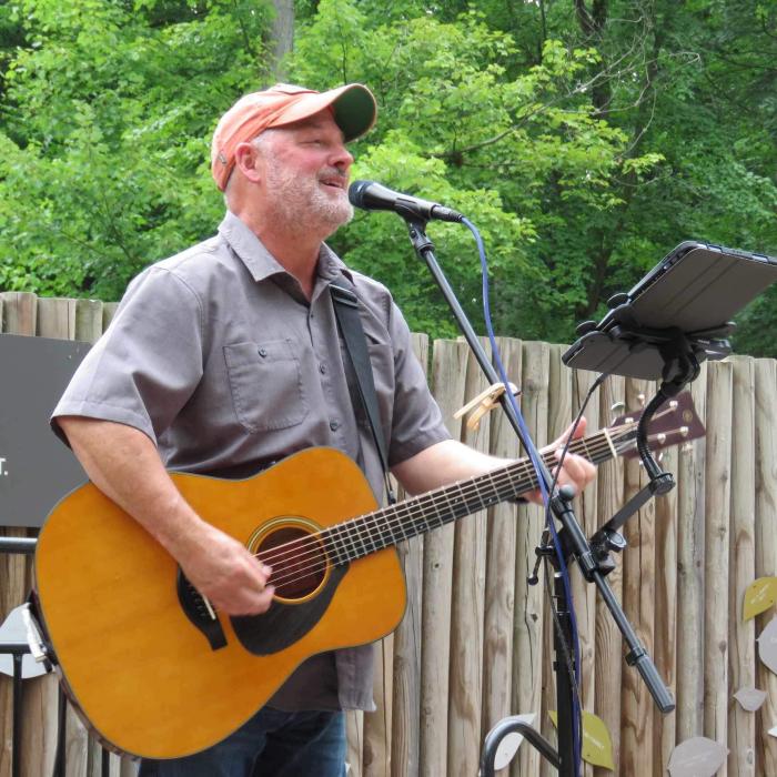 Larry Lowis playing a guitar outside